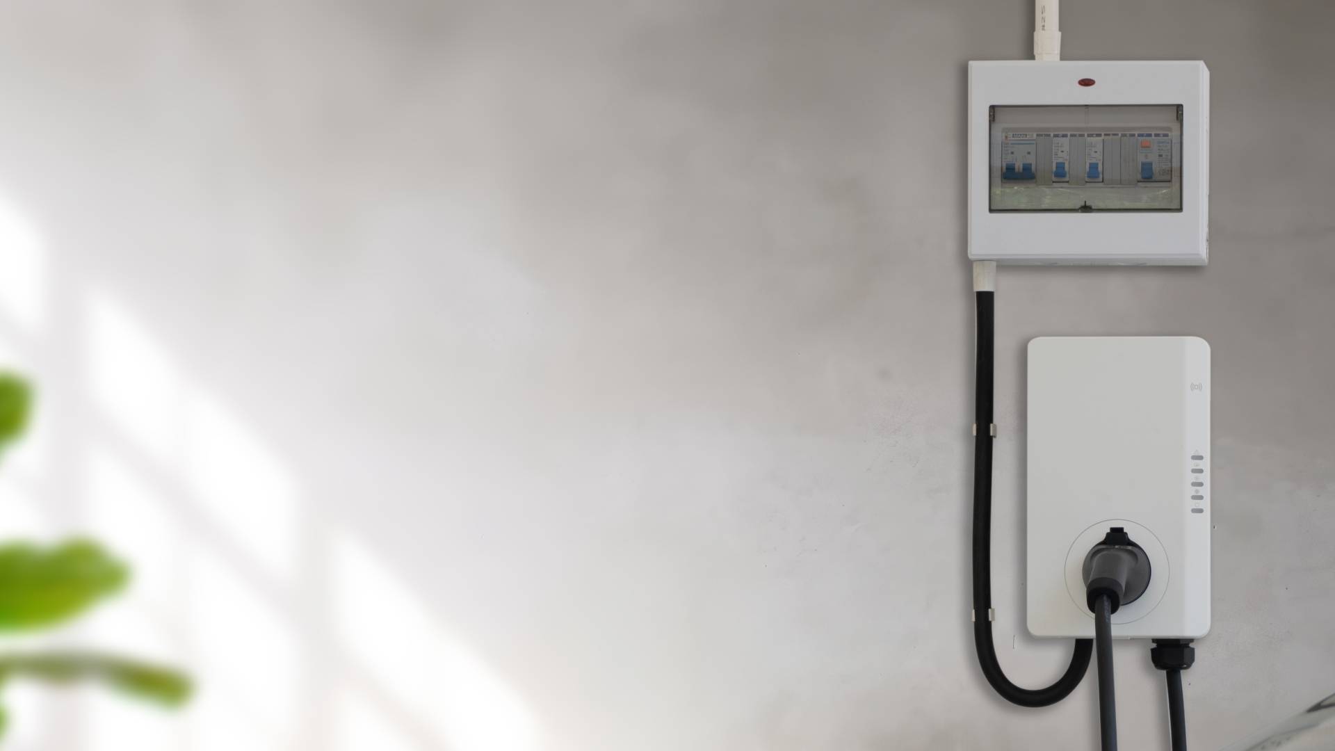 Wall mounted EV charger unit installed indoors with consumer unit and electrical cabling