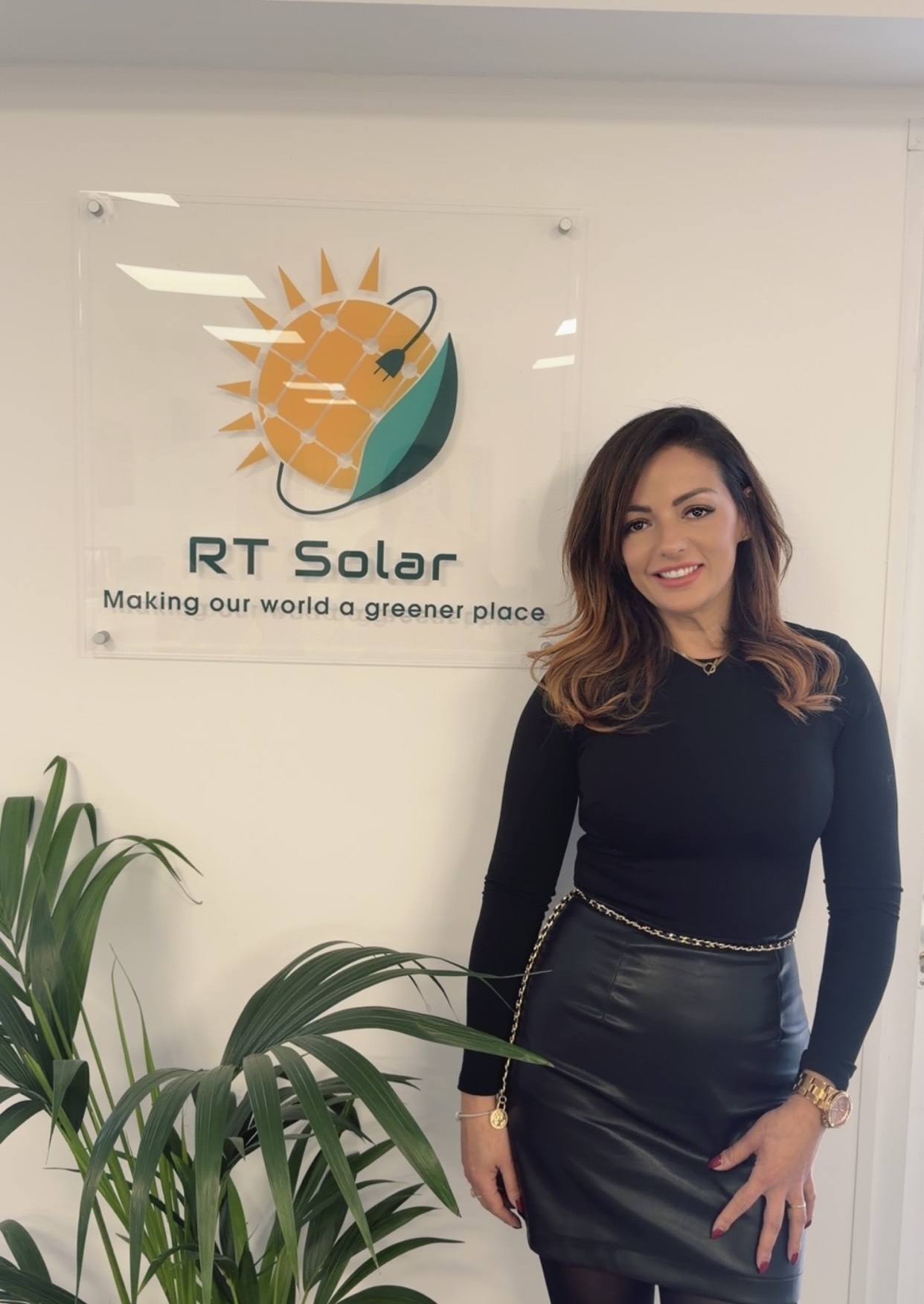 IMG_0489 RT Solar office team member standing beside company solar panel and battery storage logo sign